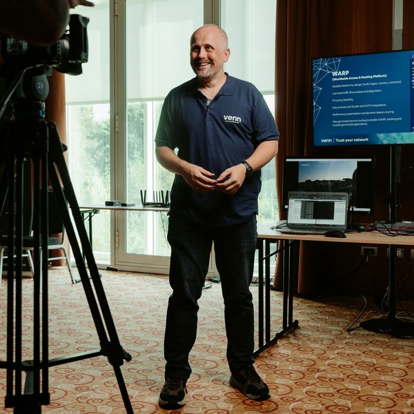 Engineer giving interview with networking equipment demonstration setup.